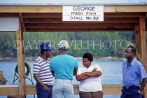 BAHAMAS, New Providence Island, Nassau, Potters Cay, locals chatting by shellfish stall, BAH195JPL