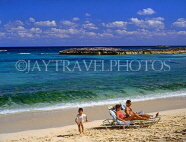 BAHAMAS, Paradise Island, beach, sunbathing couple and child, BAH355JPL