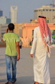 BAHRAIN, Manama, King Faisala Corniche, two men walking along promenade, BHR736JPL