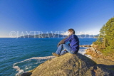 CANADA, British Columbia, VANCOUVER (West), Lighthouse Park, hiker relaxing on rock, CAN900JPL