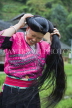 CHINA, Guangxi Province, Guilin, Long Haired Red Yao woman coiling her hair, CH1490JPL