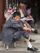 CHINA, Yunnan Province, Dali, salesman showing leg, CH1513JPL