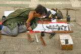 CHINA, Yunnan Province, Kunming, amputee doing caligraphy to earn a living in the streets, CH1612JPL