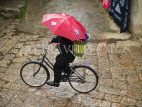 CHINA, Yunnan Province, Lijiang, cyclist riding along old town cobbled street, CH1564JPL