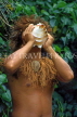 COOK ISLANDS, Rarotonga, Cultural Village, Maori man blowing conch shell, CI923JPL