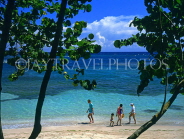 DOMINICAN REPUBLIC, North Coast, Playa Dorada, holidaymakers walking along beach, DR144JPL