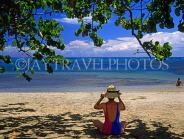 DOMINICAN REPUBLIC, North Coast, Playa Dorada, tourist relaxing, seated on beach, DR234JPL