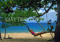 DOMINICAN REPUBLIC, North Coast, Playa Dorada beach, tourist relaxing on tree branch, DR408JPL