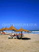 GAMBIA, Kotu Beach, sunbathers and thatched sunshades, GAM833JPL