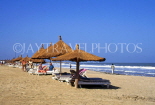 GAMBIA, Kotu Beach, sunbathers and thatched sunshades, near Kombo Beach Hotel, GAM915JPL