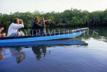 GAMBIA, River Gambia, tourists in dug out canoe (pirogue) on bird watching tour, GAM938JPL