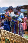GUATEMALA, Chichicastenango, women in traditional clothing, child on sling, GUA255JPL