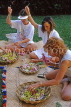 Hawaiian Islands, OAHU, tourists learning to make Leis with fresh orchids, HAW228JPL