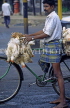 INDIA, South India, MADRAS, man transporting chickens tied onto bicycle, IND148JPL