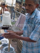 INDIA, West Bengal, Calcutta, roadside food stall, man busy making a lassi, IND1401JPL