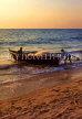 India, GOA, fishermen pushing boat out to sea, at dusk, IND664JPL