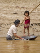 LAOS, Mekong River, girl watching grandmother washing, Lao, LAO92JPL