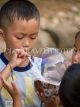 LAOS, Muang Ngoi, boy blowing bubbles from a coconut shell, LAO81JPL