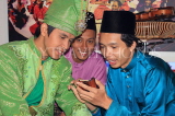 MALAYSIA, Kuala Lumpur, cultural dancers with moble phone, MSA725JPL