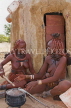 NAMIBIA, Himba tribe women cooking in front of their house, NAM191JPL