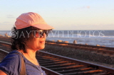 SRI LANKA, Colombo, woman by coastal rail, sunset, SLK5466JPL