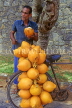 SRI LANKA, Kandy, man drinking Thambili (King Coconut Water), coconuts on bicycle, SLK1794JPL