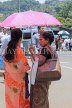 SRI LANKA, Kandy, town centre, two women chatting under umbrella, SLK4039JPL