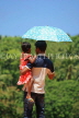 SRI LANKA, Kandy area, father and daughter, with umbrella under mid day sun, SLK2496JPL