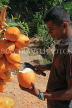 SRI LANKA, Kandy area, roadside stall selling King Coconut (Thambili), vendor cutting fruit, SLK2551JPL