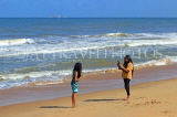 SRI LANKA, Negombo, beach, and two women taking photos, SLK6329JPL