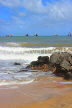 SRI LANKA, Negombo, beach, rocks, and seascape with fishing boats out at sea, SLK6342JPL