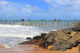 SRI LANKA, Negombo, beach, rocks, and seascape with fishing boats out at sea, SLK6343JPL