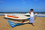 SRI LANKA, Negombo, beach and Sri Lankan woman posing by boat, SLK2453JPL