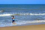 SRI LANKA, Negombo, beach and sea, couple paddling along beach, SLK6118JPL