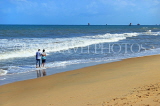 SRI LANKA, Negombo, beach and sea, couple paddling along beach, SLK6119JPL
