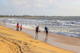 SRI LANKA, Negombo, beach and sea, people paddling along beach, SLK3538JPL