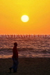 SRI LANKA, Negombo, sea and sunset, man walking along beach, SLK3609JPL