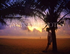 SRI LANKA, south coast, Mount Lavinia, sunset and boy leaning against coconut tree, SLK1595JPL