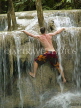 THAILAND, Kanchanaburi, Erawan Falls National Park, tourist climbing a waterfall, THA1947JPL