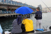 TURKEY, Istanbul, Eminonu Waterfront, couple with umbrella, by Galata Bridge, TUR1411JPL