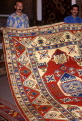 TURKEY, Istanbul, shopping, salesman displaying hand woven carpet, TUR471JPL