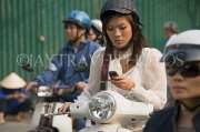 VIETNAM, Hanoi, woman using phone while riding motorbike, VT602JPL