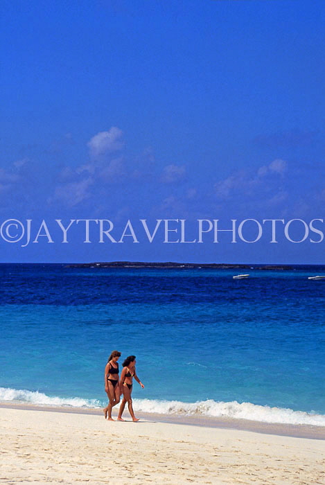 BAHAMAS, New Providence Island, Cable Beach and two tourists walking, BAH488JPL