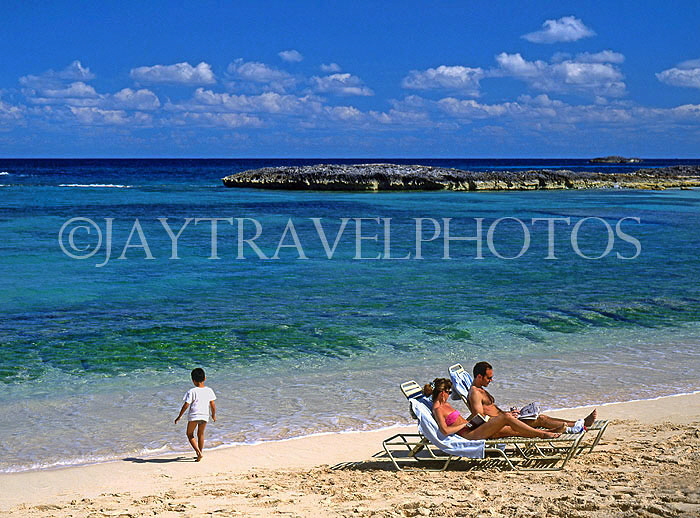 BAHAMAS, Paradise Island, beach, sunbathing couple and child, BAH351JPL