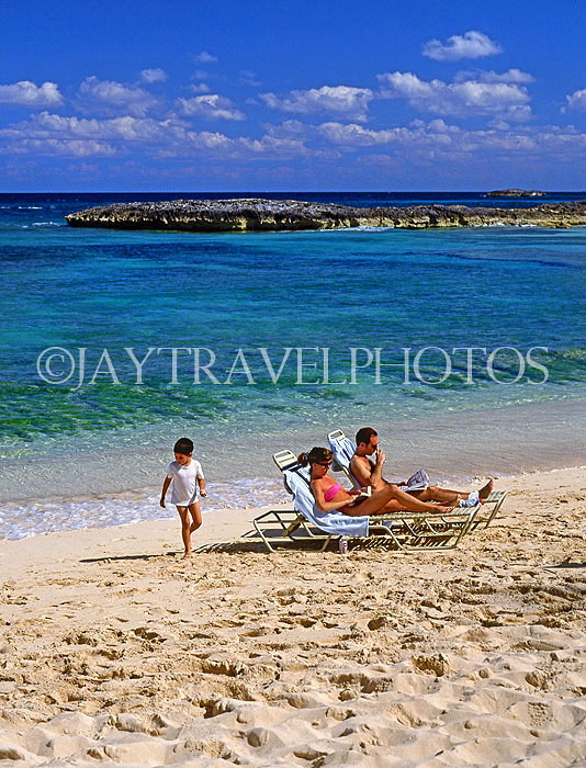 BAHAMAS, Paradise Island, beach, sunbathing couple and child, BAH353JPL