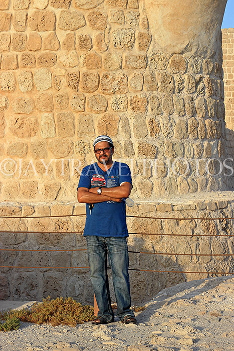 BAHRAIN, Manama, Karababad, Bahrain Fort (Qal'at al Bahrain), and man posing, BHR677JPL