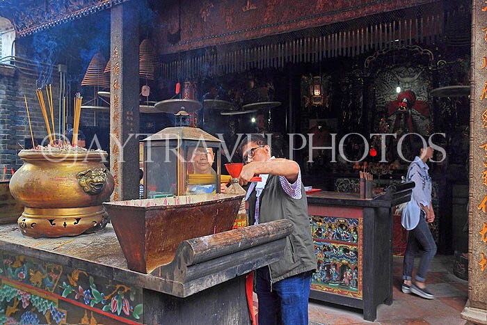 HONG KONG, Cheung Chau island, Pak Tai Temple, worshipper lighting incense, HK1500JPL