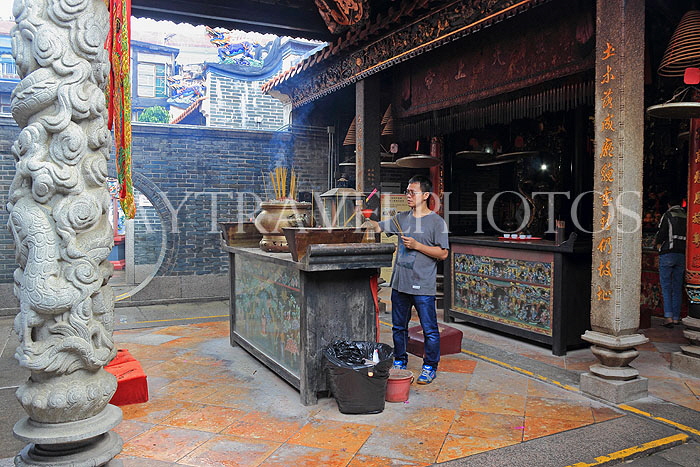 HONG KONG, Cheung Chau island, Pak Tai Temple, worshipper lighting incense, HK1501JPL
