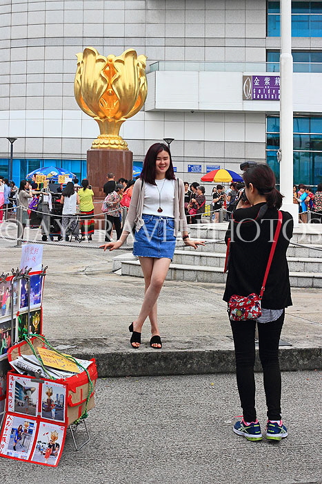 HONG KONG, Hong Kong Island, Wan Chai, Golden Bauhinia statue, tourist posing, HK2099JPL