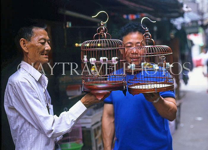 HONG KONG, Kowloon, Mong Kok, Yuen Po Street Bird Garden, two buyer with singing birds, HK292JPL